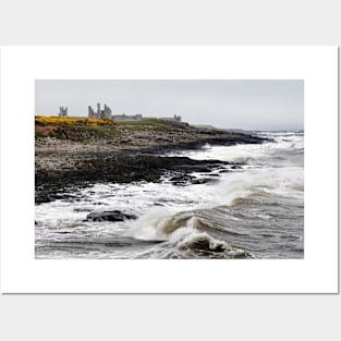 Dunstanburgh castle with rough waves battering the coast in Northumberland, UK Posters and Art